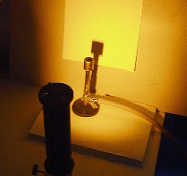 En bunsenbrænder belyses med en natriumlampe