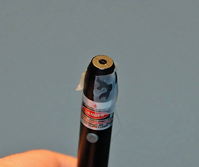 A piece of hair is attached to a laser pointer using tape